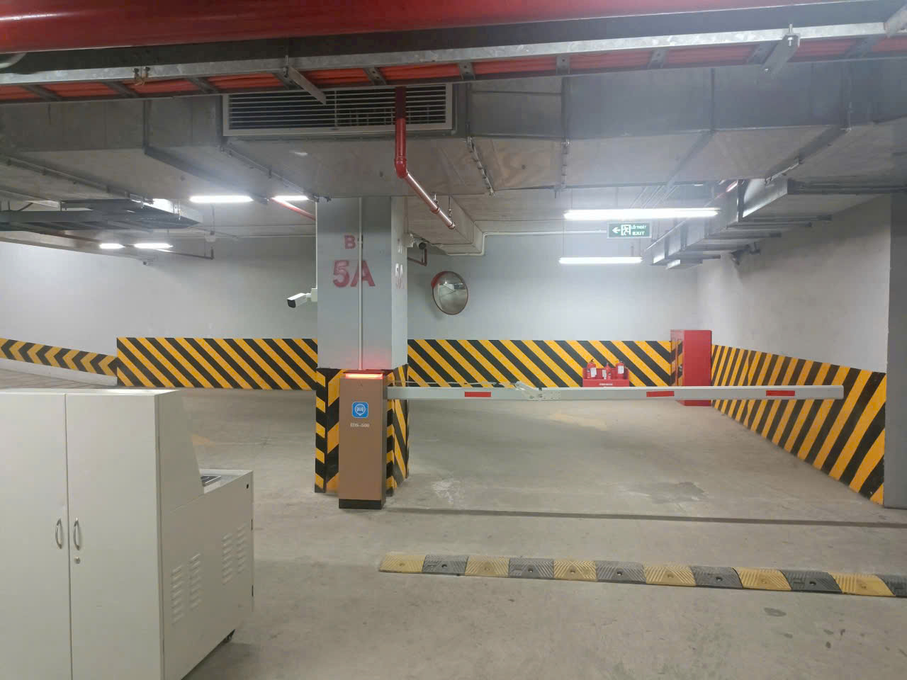Thanh chắn barie tự động tại lối vào bãi đỗ xe tầng hầm với vạch cảnh báo vàng đen